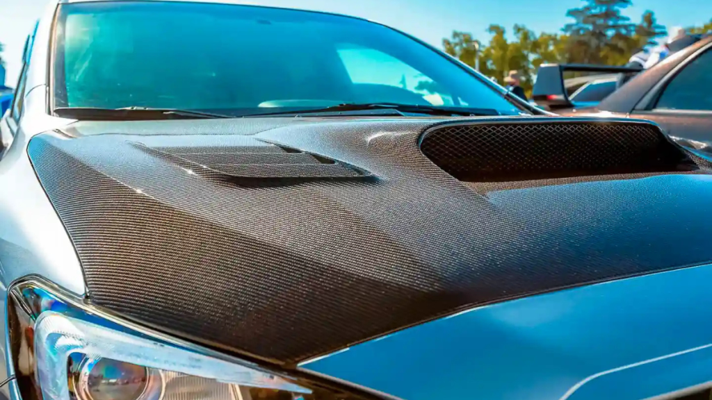 Capot automobile recouvert d’un film carbone montrant l’effet réaliste du vinyle imitation carbone.